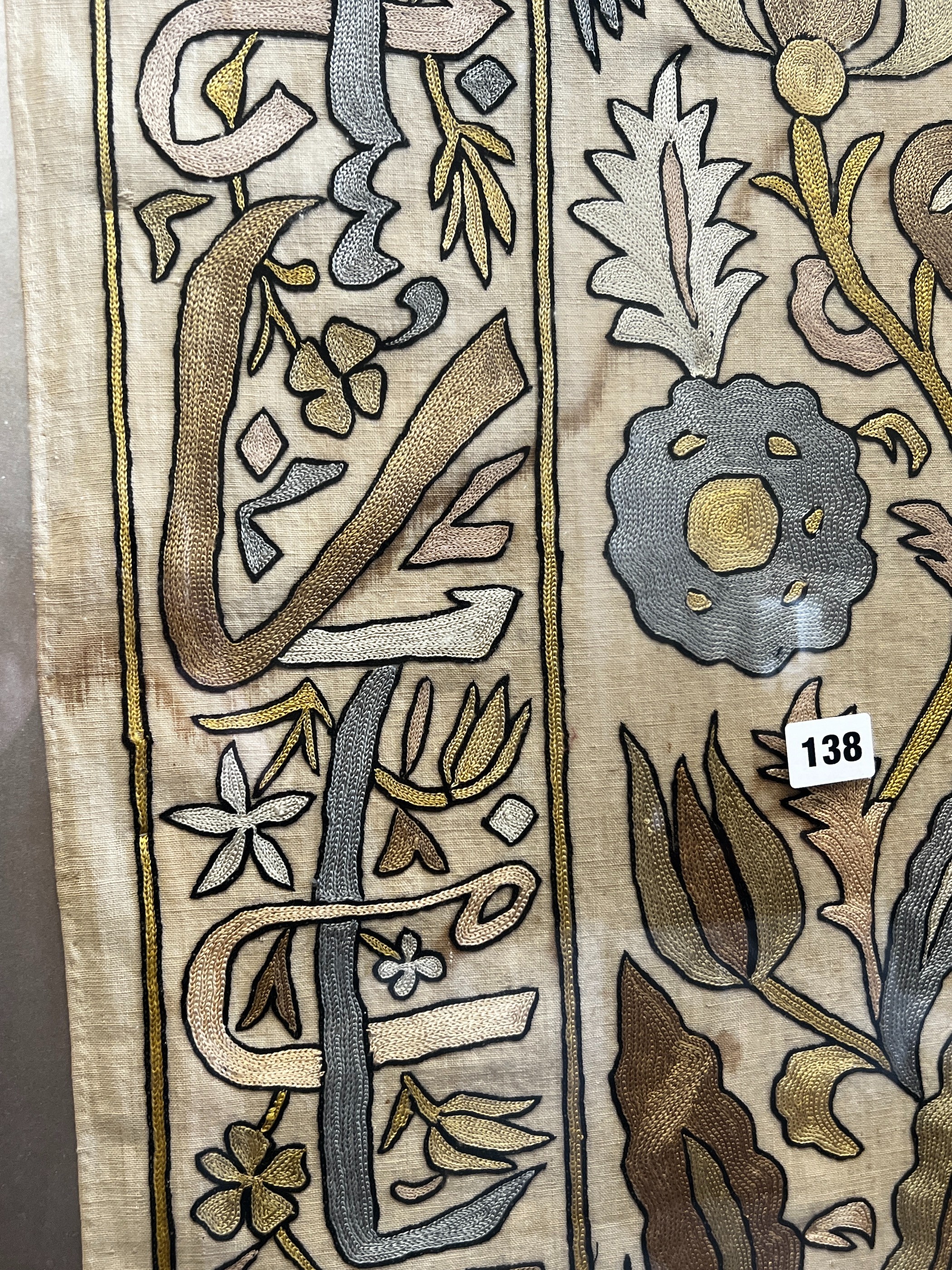 A polychrome embroidered panel, framed, the panel width 51cm, height 192cm
